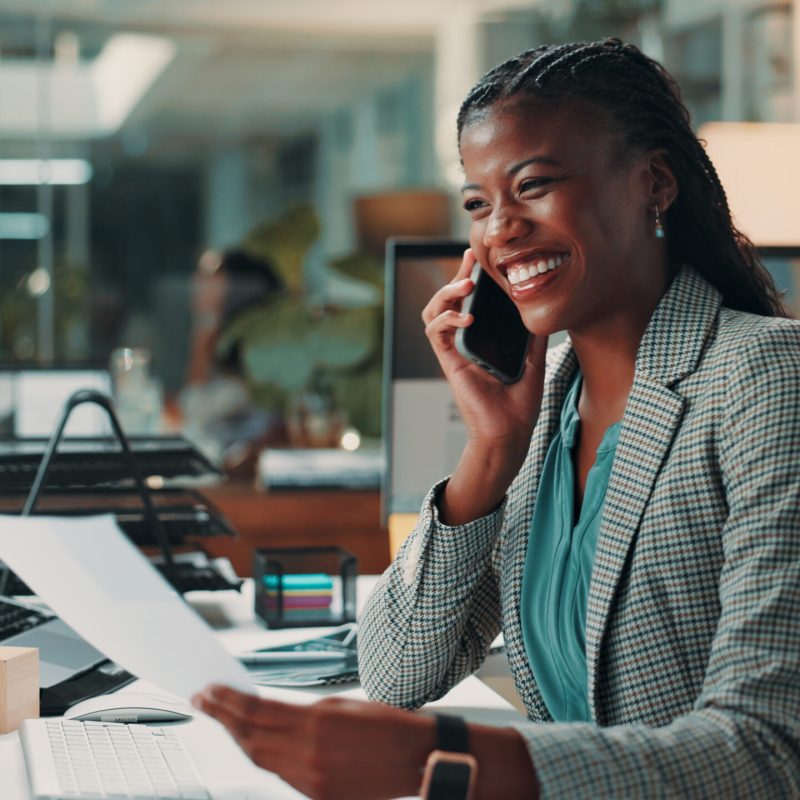 Documents, phone call and smile of business black woman in office for administration or update. Conversation, feedback and review with happy African employee in professional workplace for negotiation.